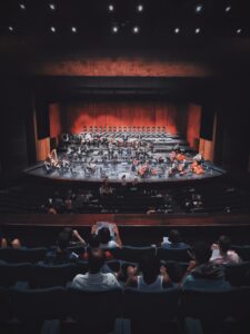 An audience watches a performance on stage.